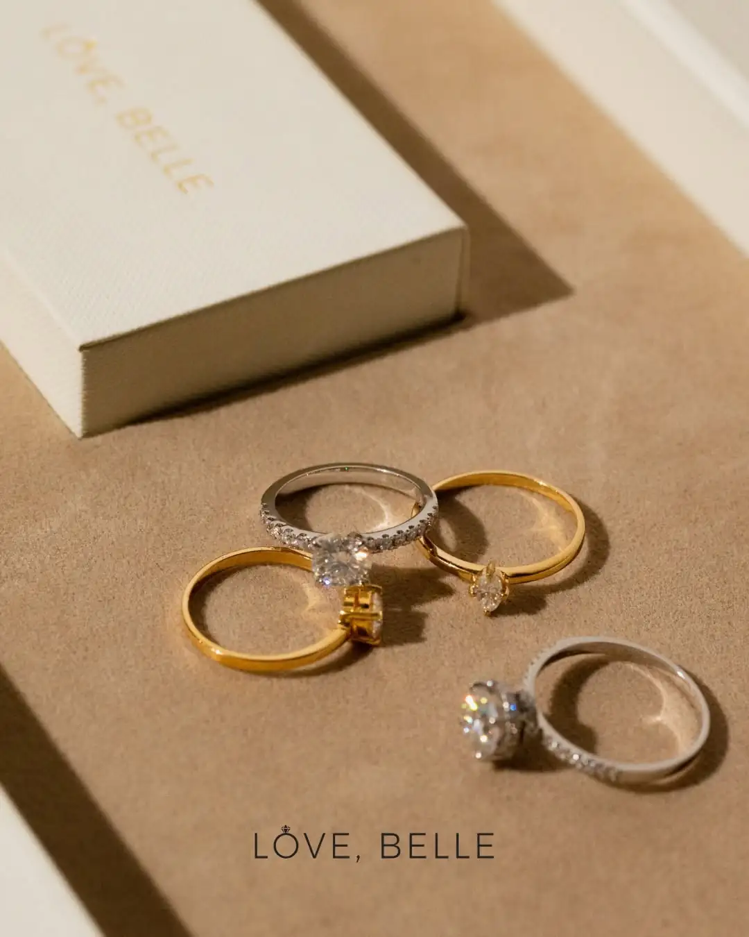 A flat-lay of Love, Belle rings beside their box